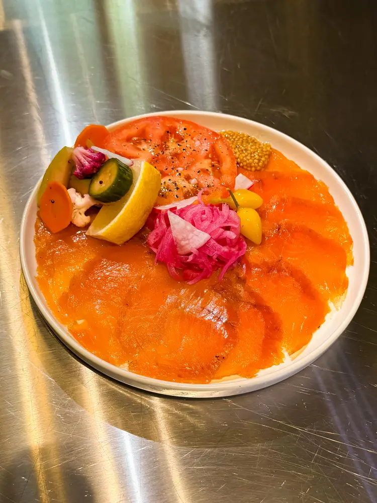 Salmón ahumado cortado a mano de Bonsai Smokehouse servido en una comida familiar en Tulum