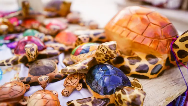 Collection of small wooden turtle figurines with painted shells in various colors and patterns arranged on a surface Collection of small wooden turtle figurines with painted shells in various colors and patterns arranged on a surface