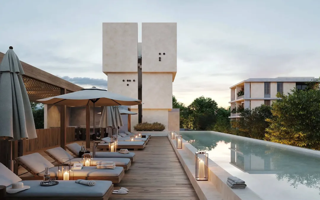Tulum Grapples With Apartment Construction Surplus Rooftop terrace with loungers, umbrellas, and an infinity pool overlooking a residential complex with modern concrete tower structures