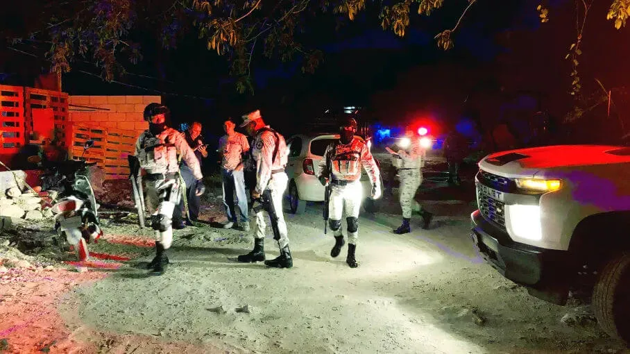 Violence in Mexico’s Caribbean Drives Tourism Decline, Hoteliers Struggle Law enforcement officers gather at a nighttime scene near overturned vehicles and emergency responders with flashing lights