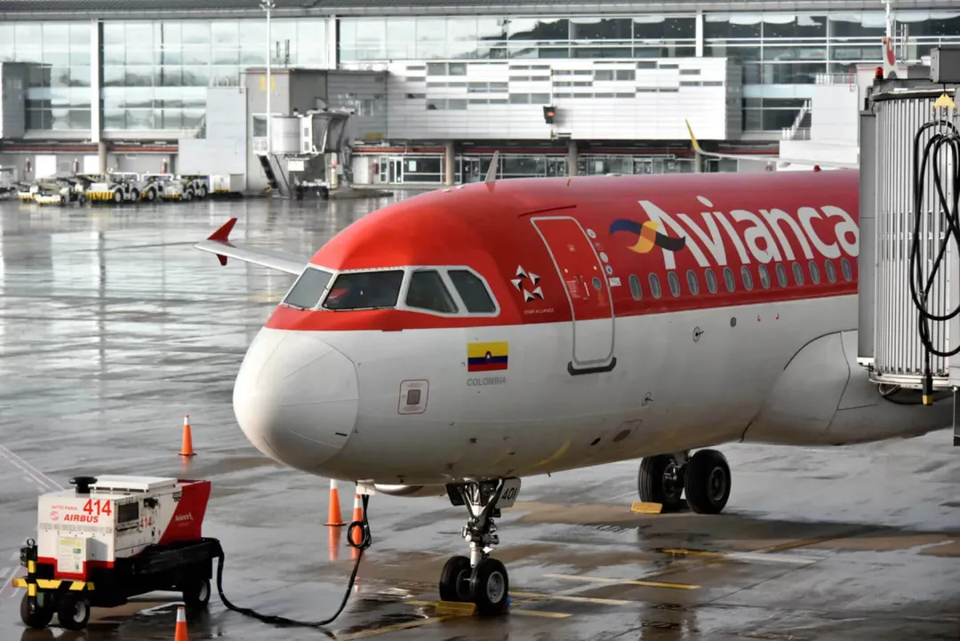 Avianca Halts Bogotá-Tulum Flights After Six-Month Run Avianca passenger aircraft parked at an airport gate with ground equipment and terminal buildings visible in the background