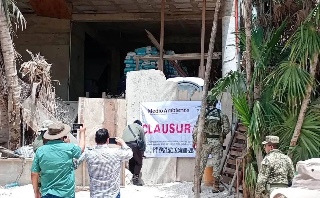 Military personnel and civilians post a closure notice on a building entrance in a residential area