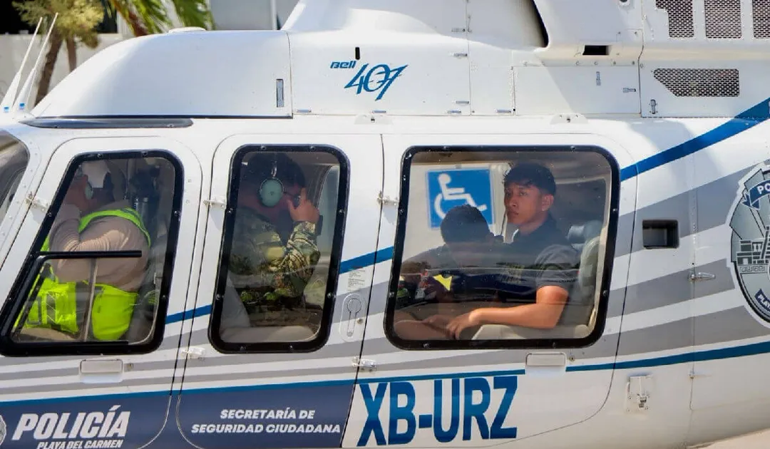 Police helicopter with personnel visible through windows, including an officer in a yellow safety vest and accessibility symbol on the fuselage