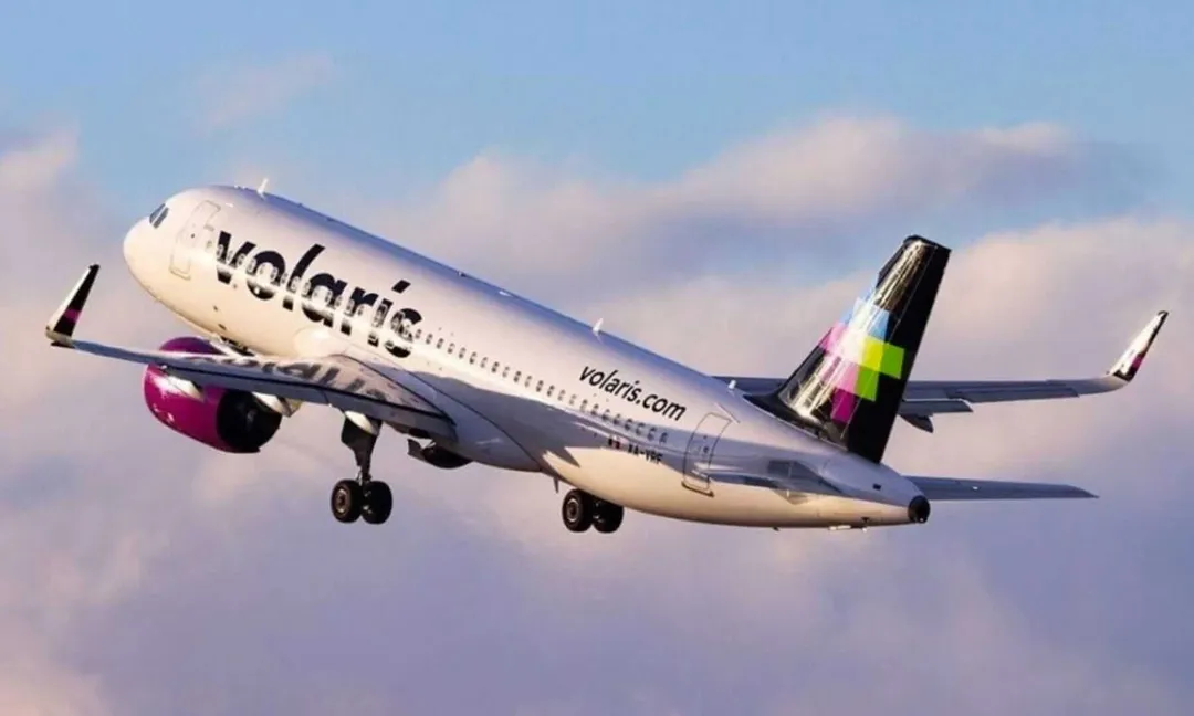 Commercial airplane in flight against a cloudy sky with landing gear down