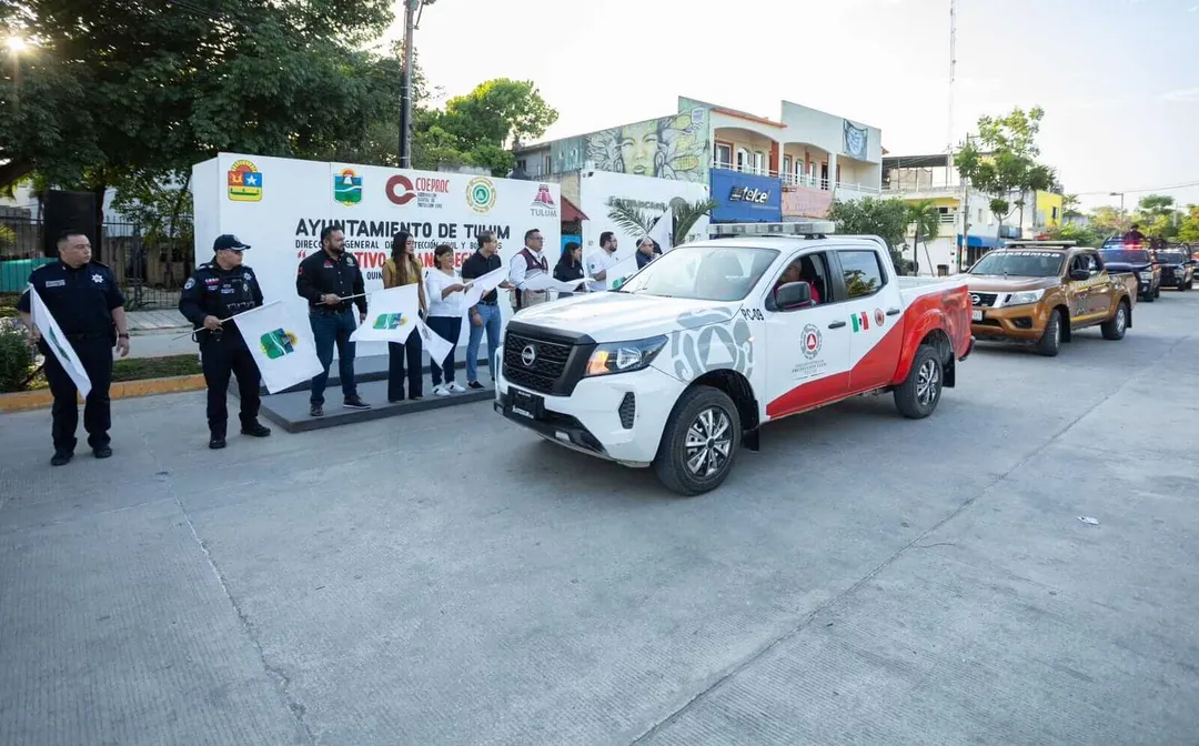 Tulum launches full-scale safety operation to support record summer tourism Police officers and officials stand beside a white and red pickup truck at a municipal event, with additional taxis and buildings visible in the background