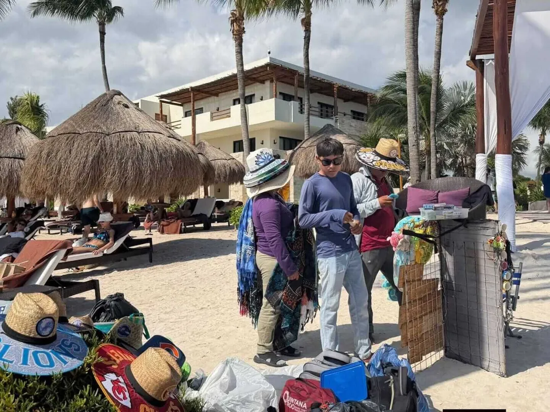 Tulum beach vendors draw warning from hotel leaders over legality Beach vendors sell hats and crafts to tourists on a sandy beach lined with palapa umbrellas and a multi-story hotel building
