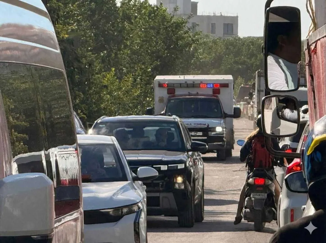 Man killed in shooting near electronic music festival in Tulum Traffic congestion on a city street with multiple vehicles including cars, a motorcycle, and an ambulance