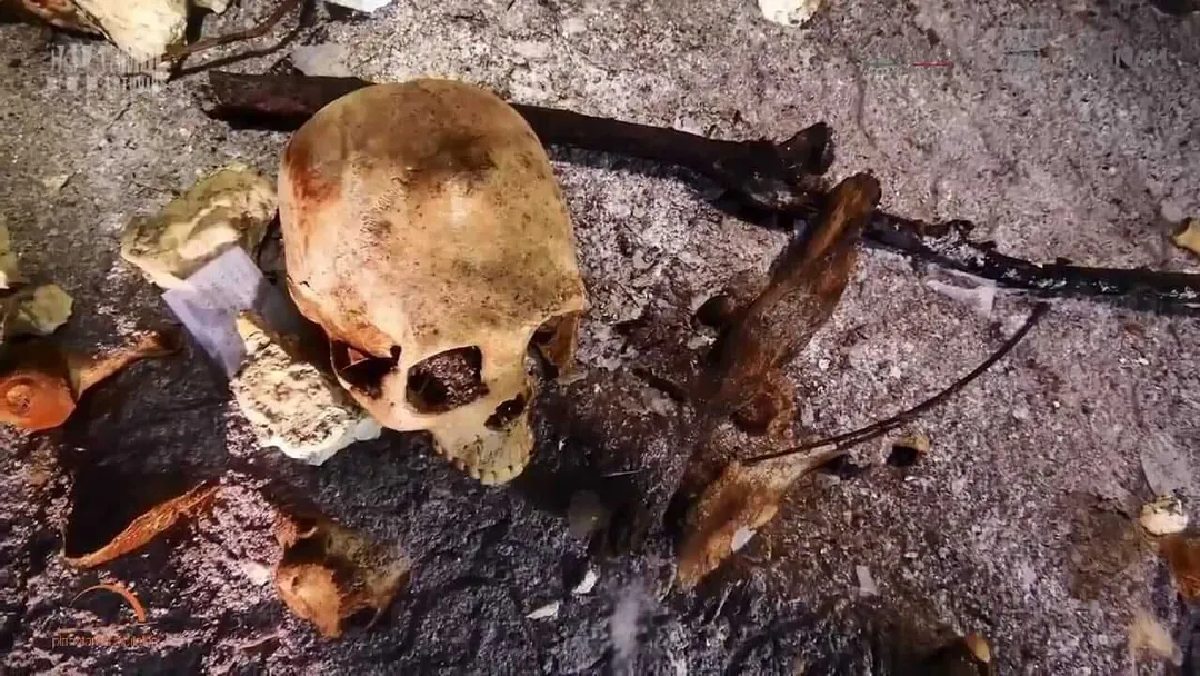 8,000-Year-Old Prehistoric Skeleton Discovered in Flooded Riviera Maya Cave Human skeletal remains and animal bones lie on a cave floor covered with sediment and debris
