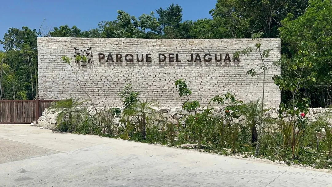 Public beach access in Tulum takes a major step forward A white stone wall with "Parque del Jaguar" text stands behind low vegetation and landscaping along a paved entrance area