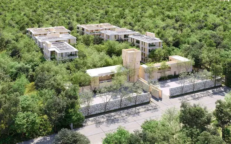 State names a Tulum development operating without a single permit Aerial view of several modern residential buildings under construction surrounded by dense green forest and stone walls