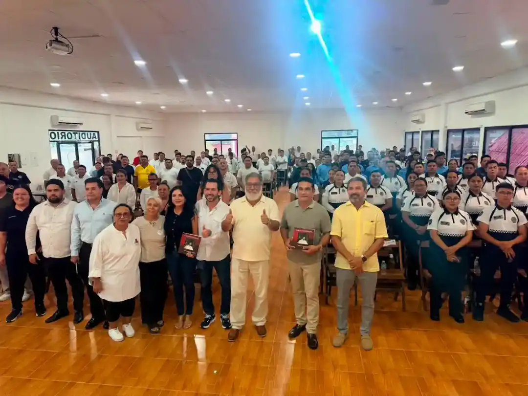 300 Taxi Drivers Took Lessons in Handling Your Emotions A large group of people gathered indoors on a wooden floor facing the camera in rows, with ceiling lights and blue lighting visible overhead