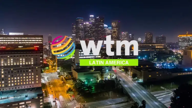 Night cityscape with illuminated skyscrapers and streets, overlaid with a colorful "wtm Latin America" logo and graphic design elements Night cityscape with illuminated skyscrapers and streets, overlaid with a colorful "wtm Latin America" logo and graphic design elements