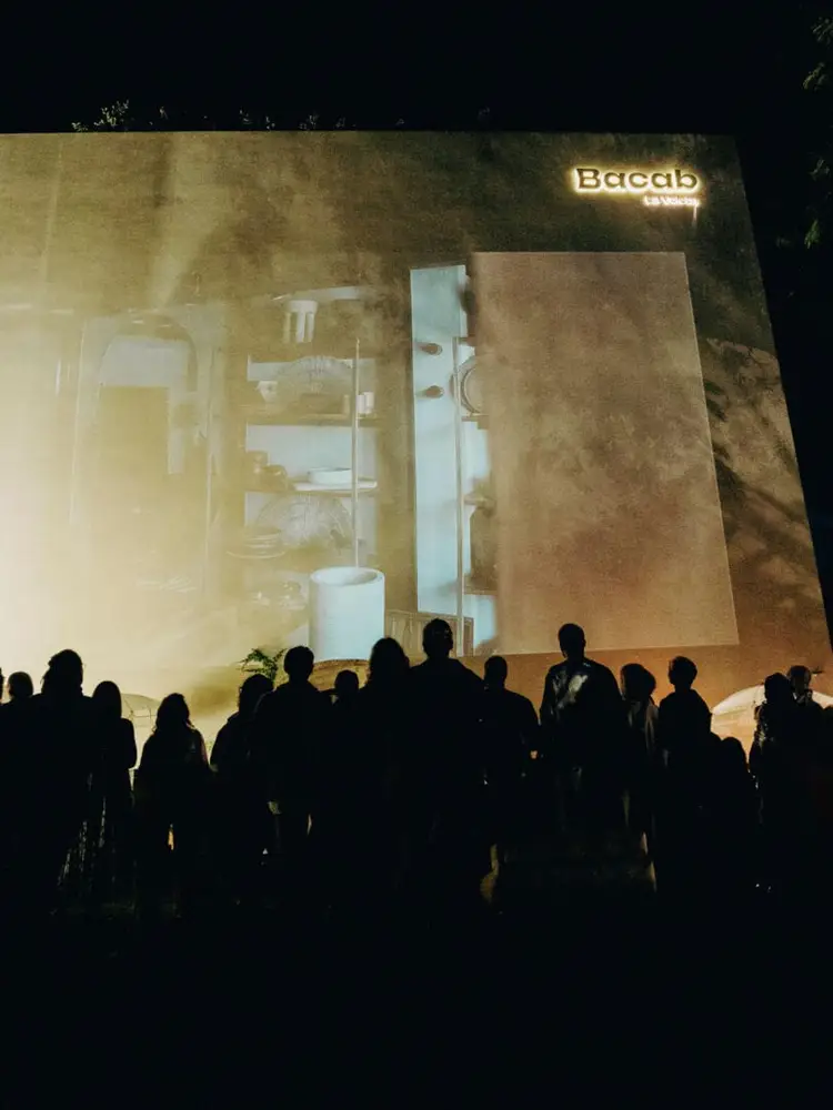 Silhouetted crowd of people viewing a large projected architectural display showing interior bathroom fixtures and layout plans for a building Silhouetted crowd of people viewing a large projected architectural display showing interior bathroom fixtures and layout plans for a building