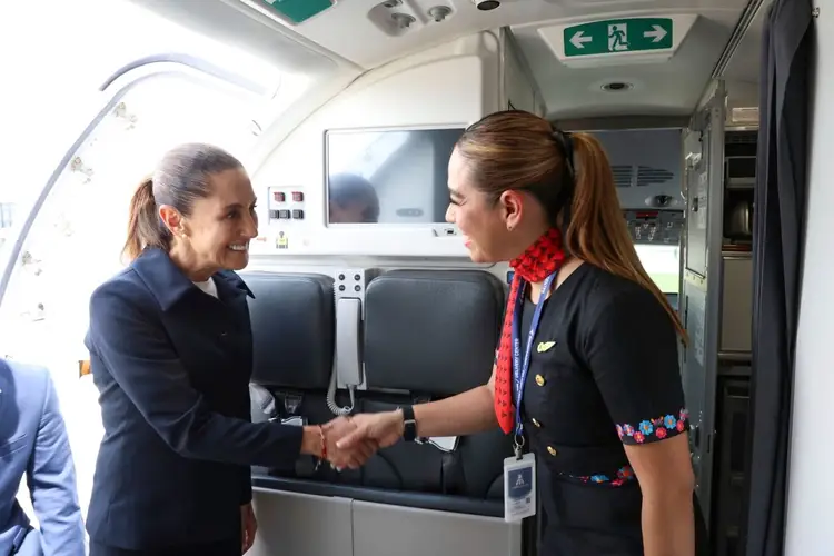 Two women in professional attire shake hands inside an aircraft cabin near the cockpit area Two women in professional attire shake hands inside an aircraft cabin near the cockpit area