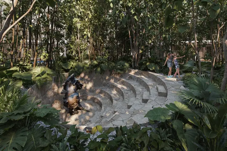 People walk through a shaded park pathway with curved stone paving surrounded by tall trees and tropical plants People walk through a shaded park pathway with curved stone paving surrounded by tall trees and tropical plants
