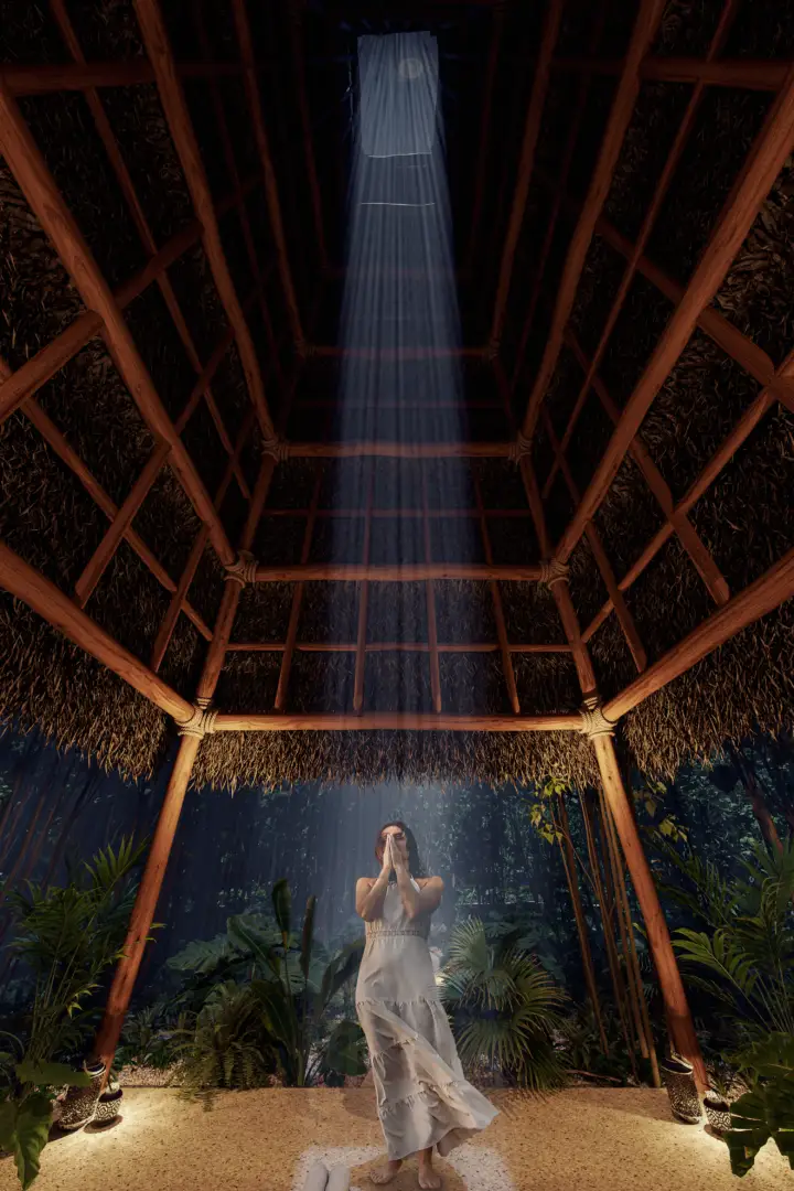 Woman in white dress stands on sand under wooden gazebo with tropical plants and rain falling at night Woman in white dress stands on sand under wooden gazebo with tropical plants and rain falling at night