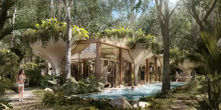 A modern curved building with large windows nestles among tall trees and tropical vegetation, with a swimming pool in the foreground and people relaxing in the