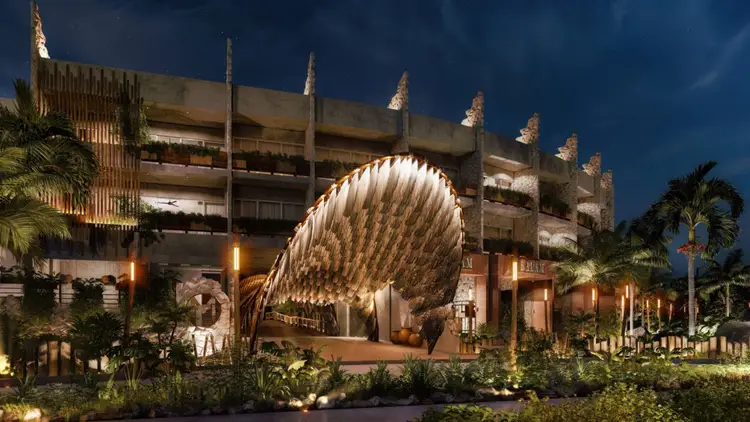 Illuminated large-scale sculptural wing installation in front of a modern hotel building at dusk, surrounded by tropical landscaping and palm trees Illuminated large-scale sculptural wing installation in front of a modern hotel building at dusk, surrounded by tropical landscaping and palm trees