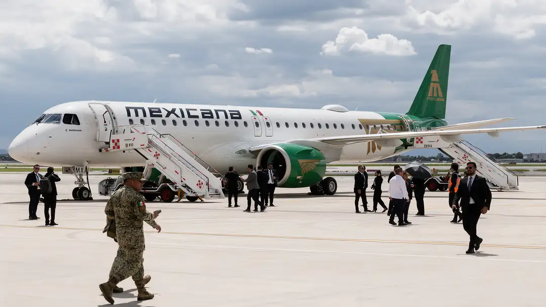 Mexicana de Aviación aircraft parked on airport tarmac with passengers and ground personnel nearby