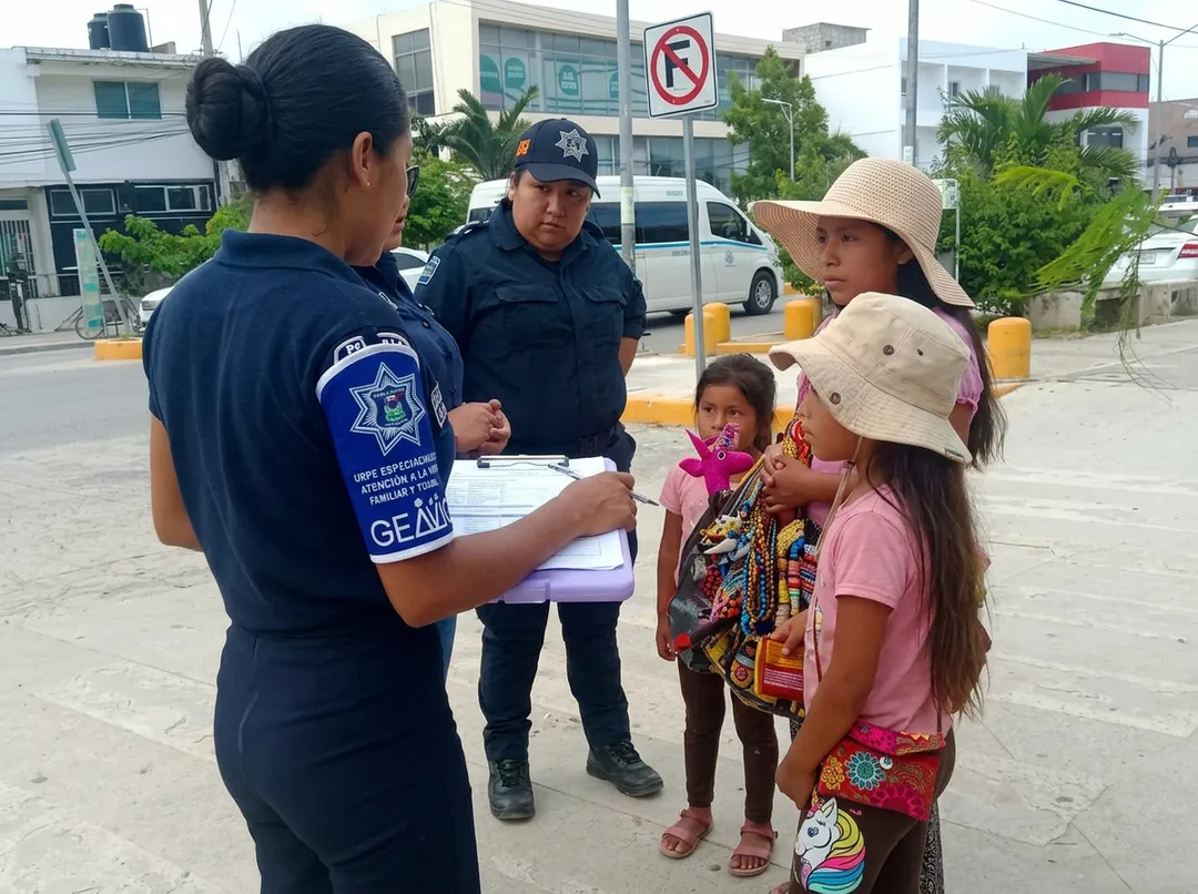 The Hidden Crisis of Child Labor in Tulum Streets Police officers speak with children and a woman in a parking lot during a street outreach