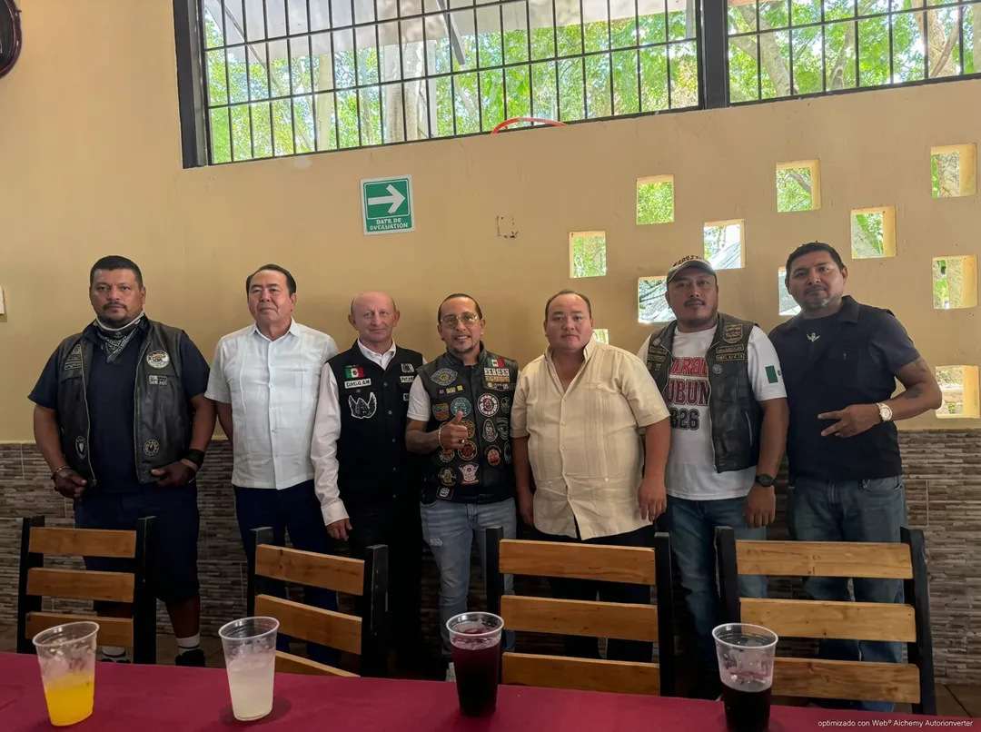 Moto Fest Tulum opens Friday, and 20 hotels are betting on 7,000 visitors Seven men wearing vests and casual clothing stand together behind a table with drinks in an indoor venue with a barred window