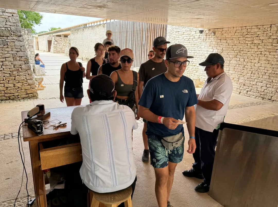 A group of people gather in an unfinished stone building for what appears to be a presentation or meeting about ticket operations
