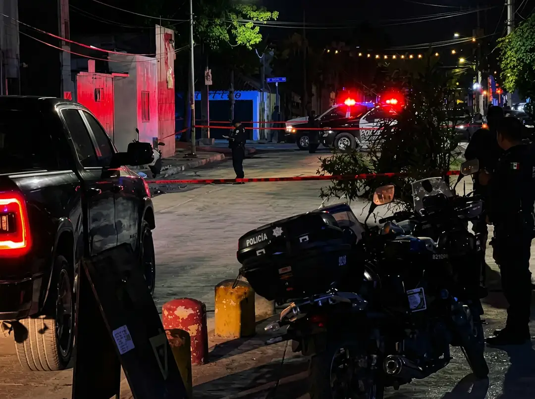 Shooting outside a Tulum nightclub kills one man and leaves a waitress hospitalized Police vehicles with emergency lights active are stationed at a nighttime street scene with officers present and red and blue tape marking an area