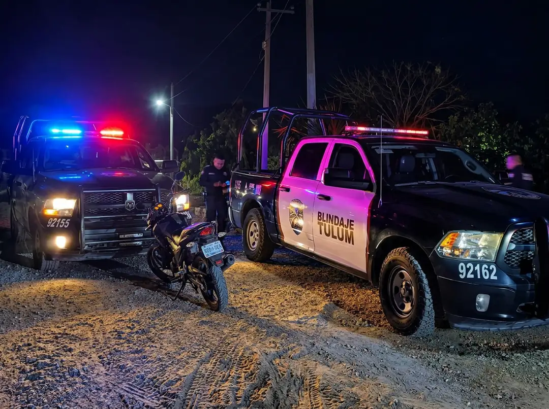 Gunmen Kill Man Known as El Moreno in Tulum's Second Homicide in Four Days Police vehicles with flashing lights and officers at a nighttime scene on a rural road