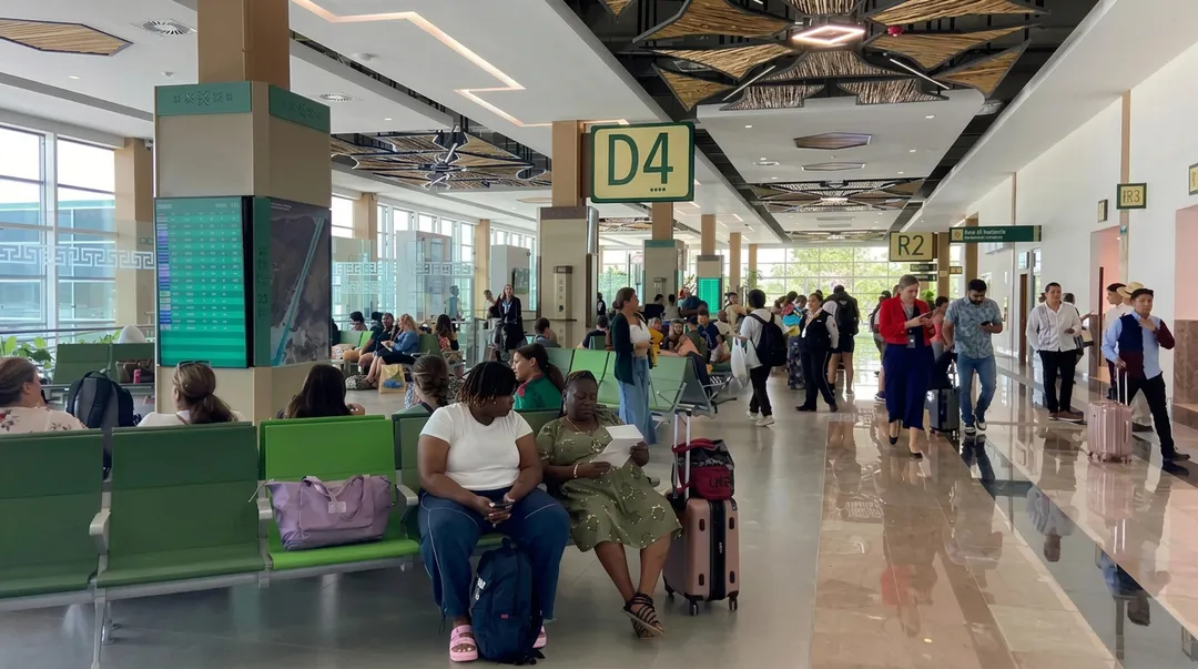 Twelve departures are the entire Newark season at Tulum's airport this winter Travelers wait in a busy airport terminal with gate signs and luggage visible throughout the corridor